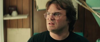 Movie still from “Be Kind Rewind” (2008), directed by Michel Gondry – A person wearing glasses and a black shirt; Close Up shot, Over the shoulder angle