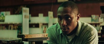 Movie still from “Be Kind Rewind” (2008), directed by Michel Gondry – A person sitting at a table; Close Up shot, Low angle