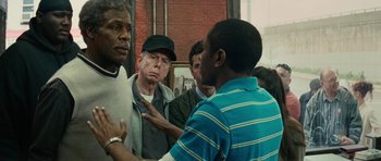 Movie still from “Be Kind Rewind” (2008), directed by Michel Gondry – A group of men standing around talking to each other; Medium shot, Over the shoulder angle