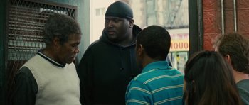 Movie still from “Be Kind Rewind” (2008), directed by Michel Gondry – A group of men standing next to each other on a sidewalk; Medium shot, Over the shoulder angle