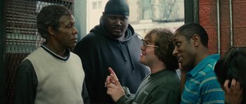 Movie still from “Be Kind Rewind” (2008), directed by Michel Gondry – A group of men standing next to each other on a street; Medium shot, Over the shoulder angle