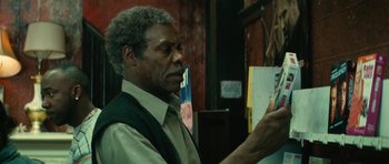 Movie still from “Be Kind Rewind” (2008), directed by Michel Gondry – An older man holding a cell phone in his hand; Close Up shot, Over the shoulder angle