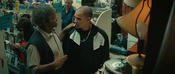 Movie still from “Be Kind Rewind” (2008), directed by Michel Gondry – A man with a shaved head talking to another man in a store; Medium shot, Over the shoulder angle