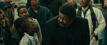 Movie still from “Be Kind Rewind” (2008), directed by Michel Gondry – A man in a black suit talking to some people; Close Up shot, Over the shoulder angle