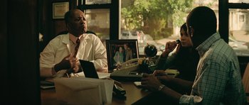 Movie still from “Be Kind Rewind” (2008), directed by Michel Gondry – A man sitting at a table in front of a computer; Medium shot, Over the shoulder angle