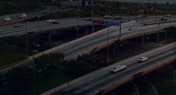 Movie still from “Beaches” (1988), directed by Garry Marshall – An aerial view of a freeway at night with cars driving down it; Extreme Wide shot, High angle