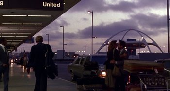 Movie still from “Beaches” (1988), directed by Garry Marshall – A group of people standing next to each other at an airport; Wide shot, Low angle