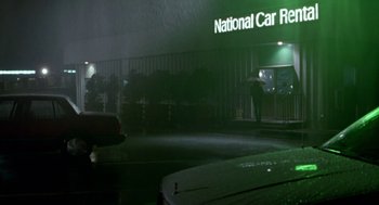 Movie still from “Beaches” (1988), directed by Garry Marshall – A person standing on the side of the street near some cars; Extreme Wide shot, Low angle