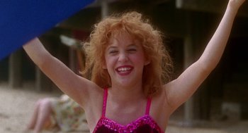 Movie still from “Beaches” (1988), directed by Garry Marshall – A young woman in a bathing suit with her arms up; Close Up shot, Low angle