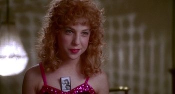 Movie still from “Beaches” (1988), directed by Garry Marshall – A young woman with red curly hair holding a picture of herself; Close Up shot, Over the shoulder angle