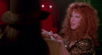 Movie still from “Beaches” (1988), directed by Garry Marshall – A woman sitting at a table holding a piece of paper in her hand; Close Up shot, Over the shoulder angle