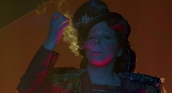 Movie still from “Beaches” (1988), directed by Garry Marshall – A woman wearing a top hat smoking a cigarette; Close Up shot, Low angle