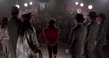 Movie still from “Beaches” (1988), directed by Garry Marshall – A group of people standing in front of an audience; Wide shot, Over the shoulder angle