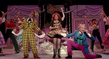 Movie still from “Beaches” (1988), directed by Garry Marshall – A group of people in costumes on stage; Wide shot, Low angle