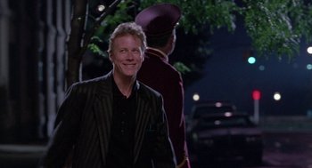 Movie still from “Beaches” (1988), directed by Garry Marshall – A man standing next to another man in a suit; Medium shot, Over the shoulder angle