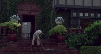 Movie still from “Beaches” (1988), directed by Garry Marshall – A man in a white suit is cleaning the steps; Wide shot, Low angle