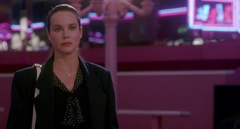 Movie still from “Beaches” (1988), directed by Garry Marshall – A woman standing in front of a neon sign; Medium shot, Over the shoulder angle