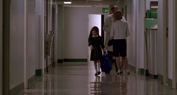 Movie still from “Beaches” (1988), directed by Garry Marshall – A little girl is walking down a hallway with her parents; Wide shot, High angle
