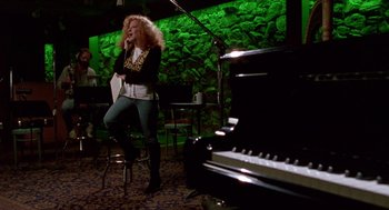 Movie still from “Beaches” (1988), directed by Garry Marshall – A woman standing on a stool in front of a piano; Wide shot, High angle