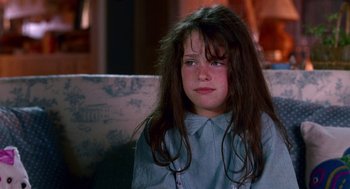 Movie still from “Beaches” (1988), directed by Garry Marshall – A young girl sitting on a couch looking at the camera; Close Up shot, High angle