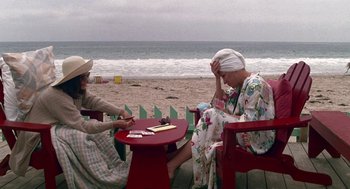 Movie still from “Beaches” (1988), directed by Garry Marshall – Two women sitting at a table playing cards on the beach; Medium shot, High angle