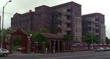 Movie still from “Beaches” (1988), directed by Garry Marshall – Two people walking down the street in front of a building; Extreme Wide shot, Low angle