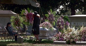 Movie still from “Beaches” (1988), directed by Garry Marshall – A woman standing in front of an open casket; Wide shot, High angle