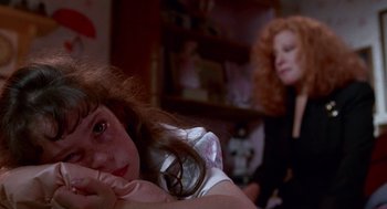 Movie still from “Beaches” (1988), directed by Garry Marshall – A young girl sitting in front of a woman; Close Up shot, High angle