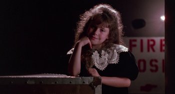 Movie still from “Beaches” (1988), directed by Garry Marshall – A young girl wearing a black dress and a white collar; Close Up shot, Over the shoulder angle