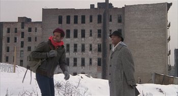 Movie still from “Beat Street” (1984), directed by Stan Lathan – Two people standing in front of an abandoned building; Wide shot, Low angle