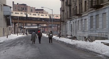 Movie still from “Beat Street” (1984), directed by Stan Lathan – A group of people walking down a street; Extreme Wide shot, Low angle