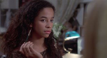 Movie still from “Beat Street” (1984), directed by Stan Lathan – A young woman holding a pencil in her right hand; Close Up shot, Over the shoulder angle