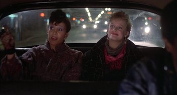 Movie still from “Beat Street” (1984), directed by Stan Lathan – Two women sitting in the back seat of a car; Close Up shot, Over the shoulder angle