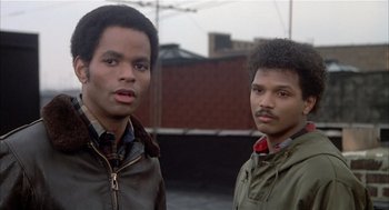 Movie still from “Beat Street” (1984), directed by Stan Lathan – Two men standing next to each other on a rooftop; Close Up shot, Low angle