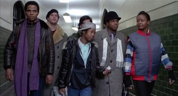 Movie still from “Beat Street” (1984), directed by Stan Lathan – A group of men standing next to each other in a hallway; Medium shot, Low angle