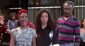 Movie still from “Beat Street” (1984), directed by Stan Lathan – A group of people standing next to each other on a stage; Medium shot, High angle