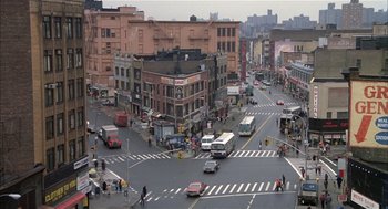 Movie still from “Beat Street” (1984), directed by Stan Lathan – A busy city street with cars , buses , and pedestrians; Extreme Wide shot, High angle