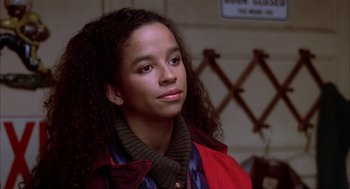 Movie still from “Beat Street” (1984), directed by Stan Lathan – A young woman with long curly hair wearing a red jacket; Close Up shot, High angle