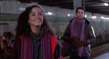 Movie still from “Beat Street” (1984), directed by Stan Lathan – Two people standing next to each other on a street; Medium shot, Over the shoulder angle