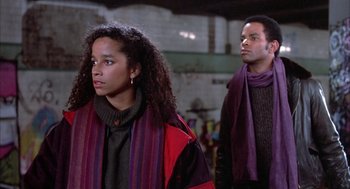 Movie still from “Beat Street” (1984), directed by Stan Lathan – A man and a woman standing next to each other; Medium shot, Low angle