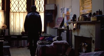 Movie still from “Beat Street” (1984), directed by Stan Lathan – A person standing in a room with a lot of stuff on the floor; Wide shot, High angle