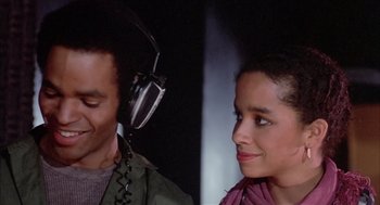 Movie still from “Beat Street” (1984), directed by Stan Lathan – A man and a woman with headphones on; Close Up shot, High angle