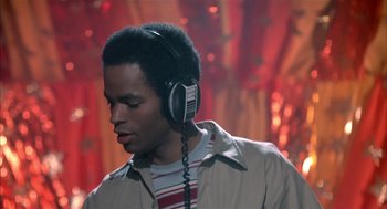 Movie still from “Beat Street” (1984), directed by Stan Lathan – A man with headphones is listening to music; Close Up shot, Low angle