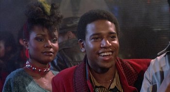 Movie still from “Beat Street” (1984), directed by Stan Lathan – A man and a woman smiling for the camera; Close Up shot, Low angle