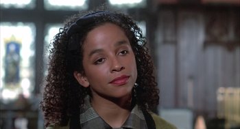 Movie still from “Beat Street” (1984), directed by Stan Lathan – A woman with curly black hair wearing a plaid shirt; Close Up shot, High angle
