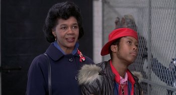 Movie still from “Beat Street” (1984), directed by Stan Lathan – A woman standing next to a man in a red hat; Close Up shot, Low angle