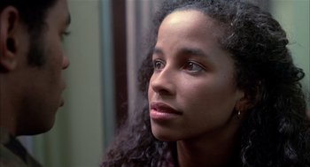Movie still from “Beat Street” (1984), directed by Stan Lathan – A person with curly black hair; Close Up shot, Over the shoulder angle
