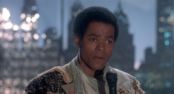 Movie still from “Beat Street” (1984), directed by Stan Lathan – A person holding a microphone; Close Up shot, Low angle