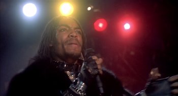 Movie still from “Beat Street” (1984), directed by Stan Lathan – A man holding a microphone in front of a crowd; Close Up shot, Low angle
