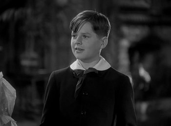 Movie still from “Beau Geste” (1939), directed by William A. Wellman – A young boy in a suit and tie looking to his left; Close Up shot, High angle